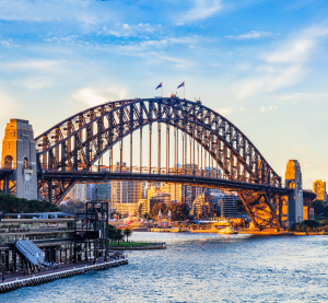 Blick auf die Br&uuml;cke in Sydney mit leicht bew&ouml;lktem Himmel und Abendd&auml;mmerung. 