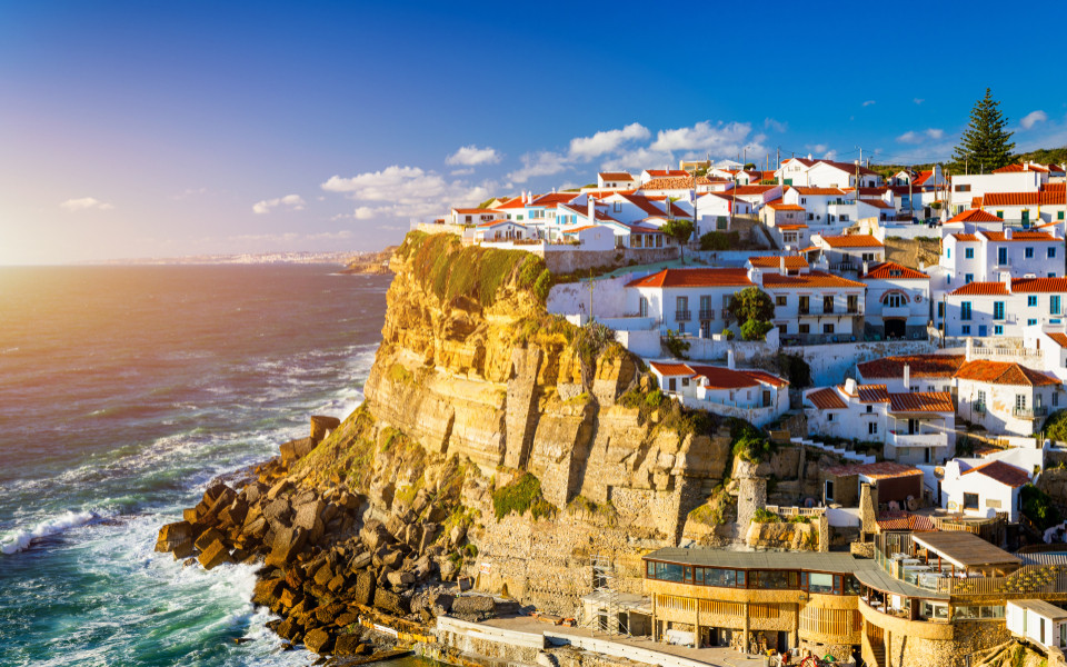 Malerisches K&uuml;stendorf Azenhas do Mar nahe Sintra, mit wei&szlig;en H&auml;usern auf steilen Klippen, spektakul&auml;rem Blick auf den Atlantik und goldenem Sonnenlicht.