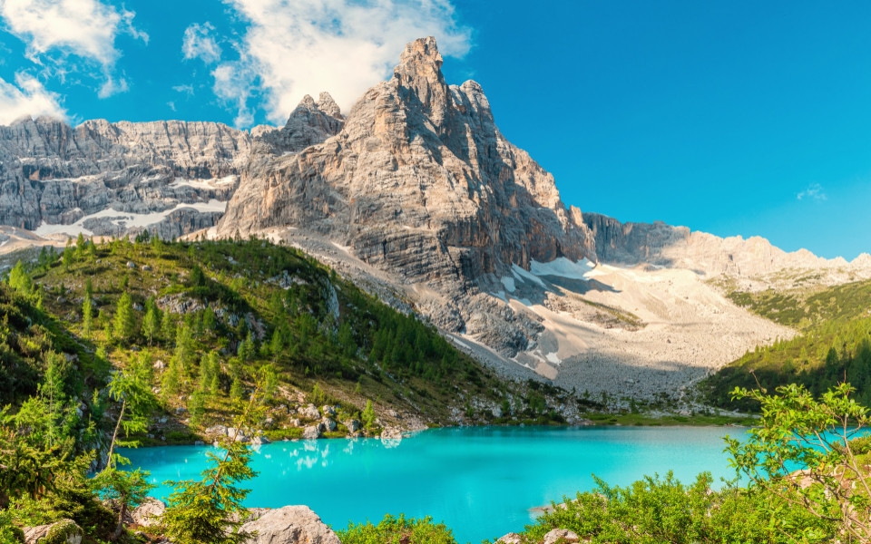 Blick auf den Lago di Sorapis mit türkisfarbenem Wasser, im Hintergrund eine Felslandschaft